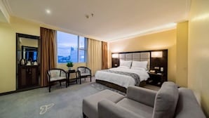 Una habitación de hotel con una cama, un sofá, un escritorio y una silla.