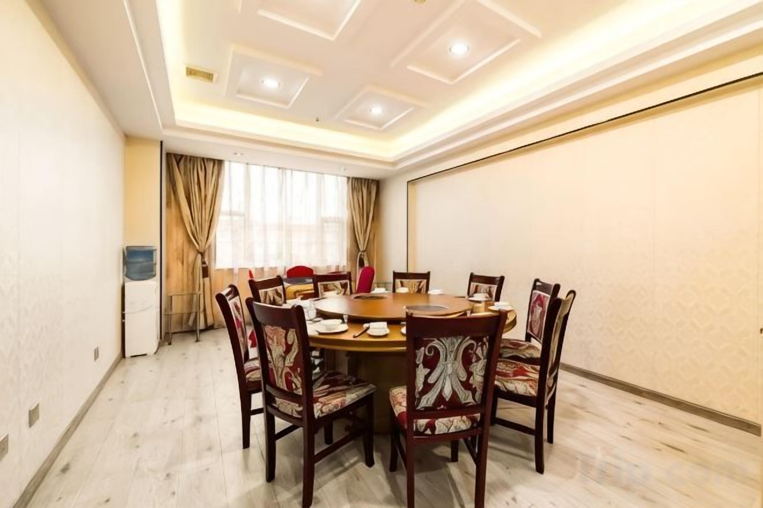 A conference room with a round table, chairs, and a projector screen.
