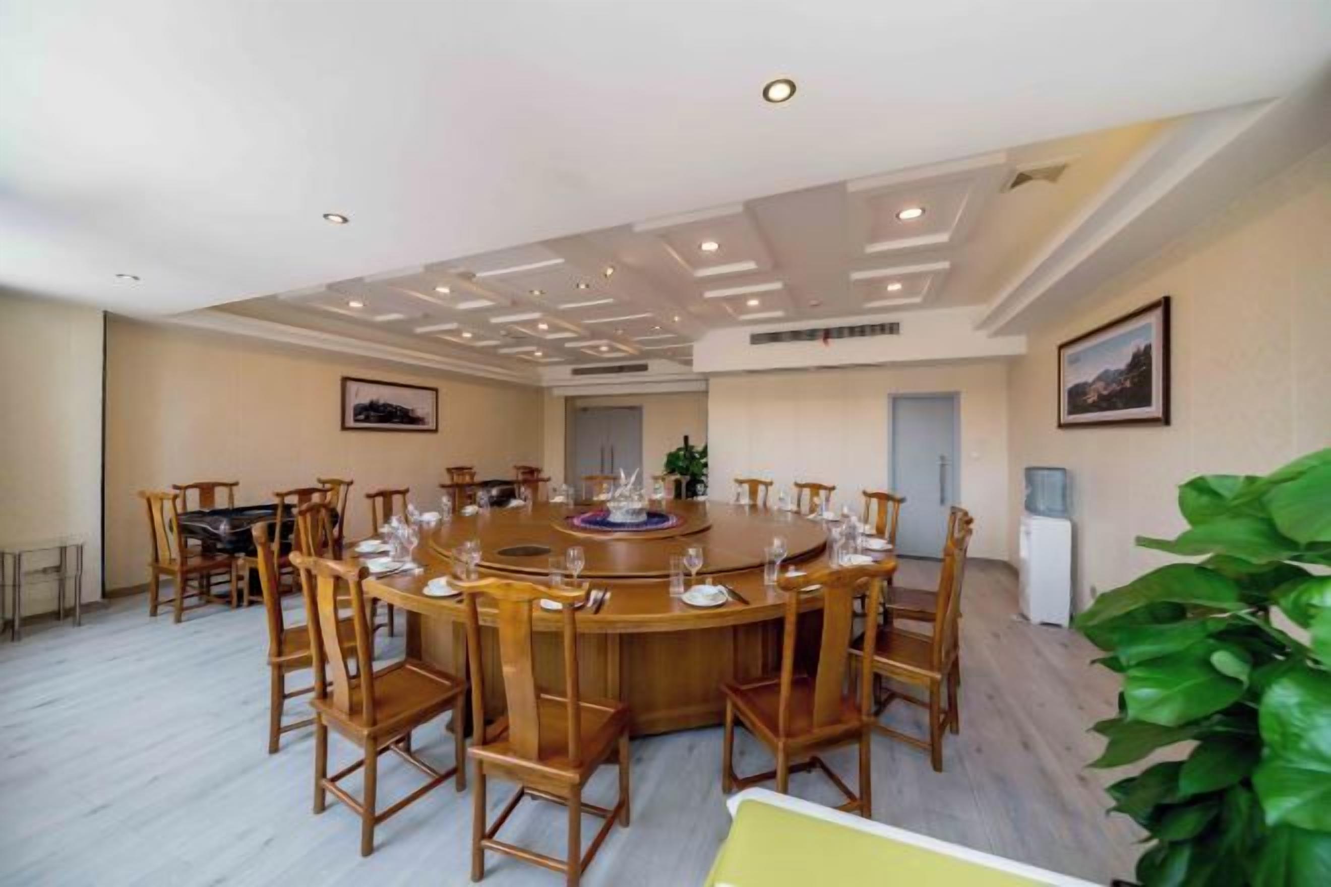 A conference room with a round table, chairs, and a large window.