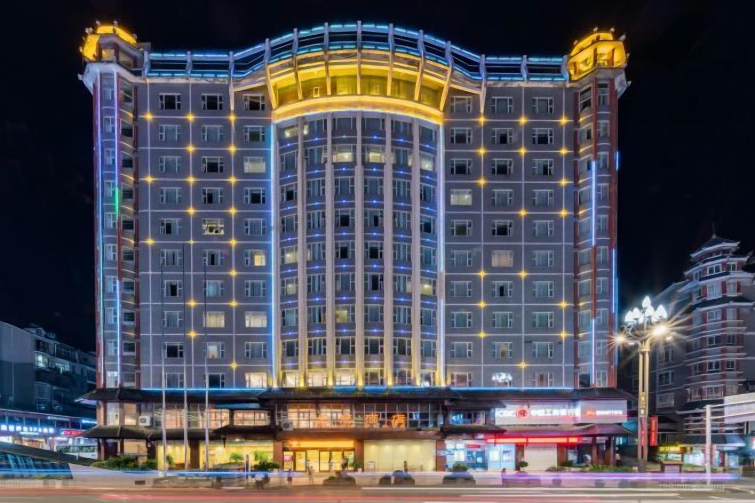 A multi-story hotel with a prominent curved facade, multiple windows, and a ground-level entrance.