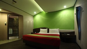 A hotel room with a large bed, a bedside table, a nightstand, and a green accent wall. - Hotel y Villas Vento (Ecatepec de Morelos)