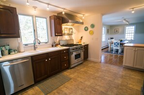 Fully stocked kitchen with stainless steel appliances.