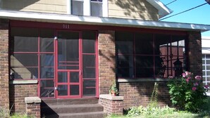 A building with a red door, numbered 911, and a brick facade. - Downtown St. Joe! Walk to BEACH & EVERYTHING! Clean & Comfortable!  Best Value! (St. Joseph)