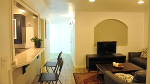 Una sala de estar moderna con televisor, sofá y mesa de centro.