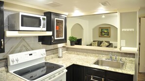 Una cocina moderna con microondas, estufa y pileta incorporados.