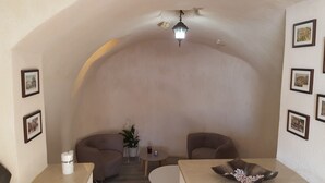 Una sala spa con due poltrone, un tavolino, una lampada e quadri appesi alle pareti.