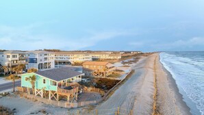 A beachfront property with multiple buildings, a sandy beach, and a view of the ocean.