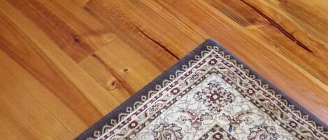 Une pièce avec un poêle à bois, un tapis à motifs et un plancher en bois.