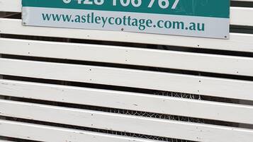 Segnaletica per Astley Cottage, che indica tariffe flessibili, spa e ambiente accogliente, con numeri di contatto e indirizzo web.