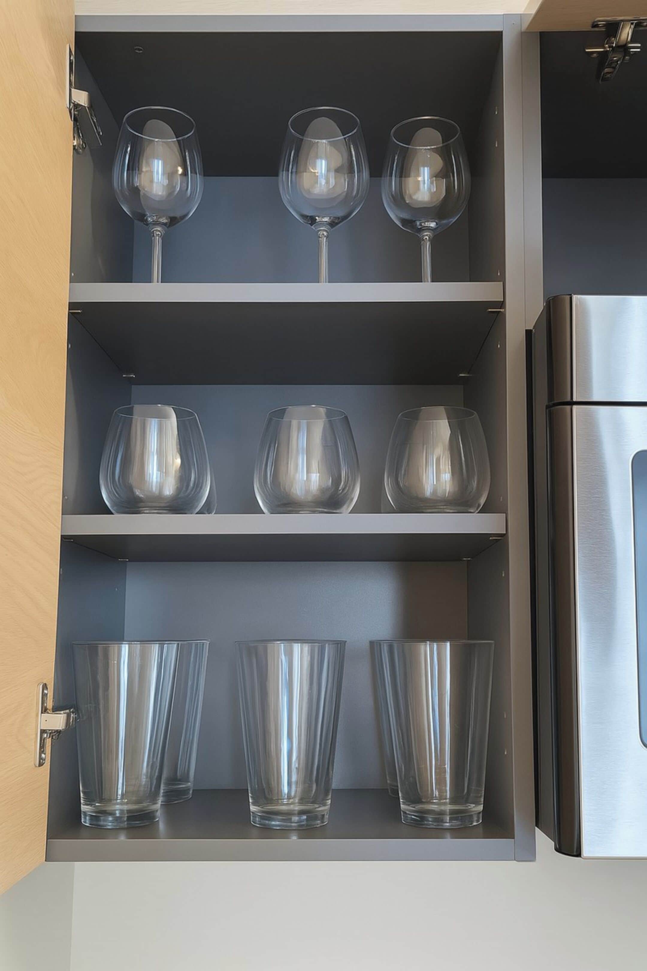 Un mueble de cocina con copas de vino y vasos.