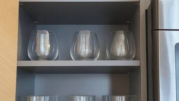 Un mueble de cocina con copas de vino y vasos.
