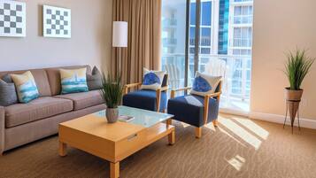 A modern living room with a sofa, two armchairs, a coffee table, and a large window with a view of a building.