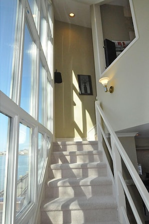 Stunning views of the water await at the top of this staircase, flanked by large windows.