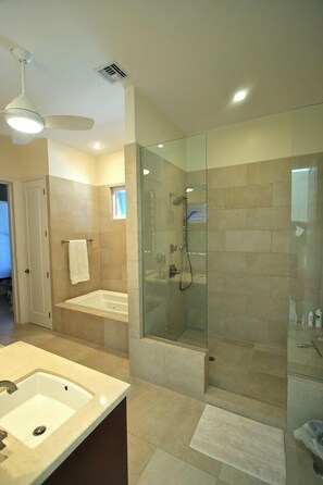 A modern bathroom with a glass-enclosed shower, a freestanding bathtub, and a vanity with a sink. - Stunning Panoramic View - Oceanfront Villa - Calming Charm (Long Bay)