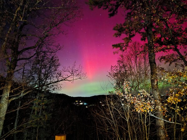 Cielo nocturno con una aurora visible.