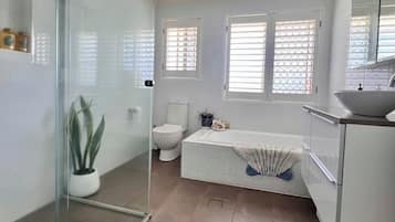 Bathtub, rainfall showerhead, hair dryer, towels