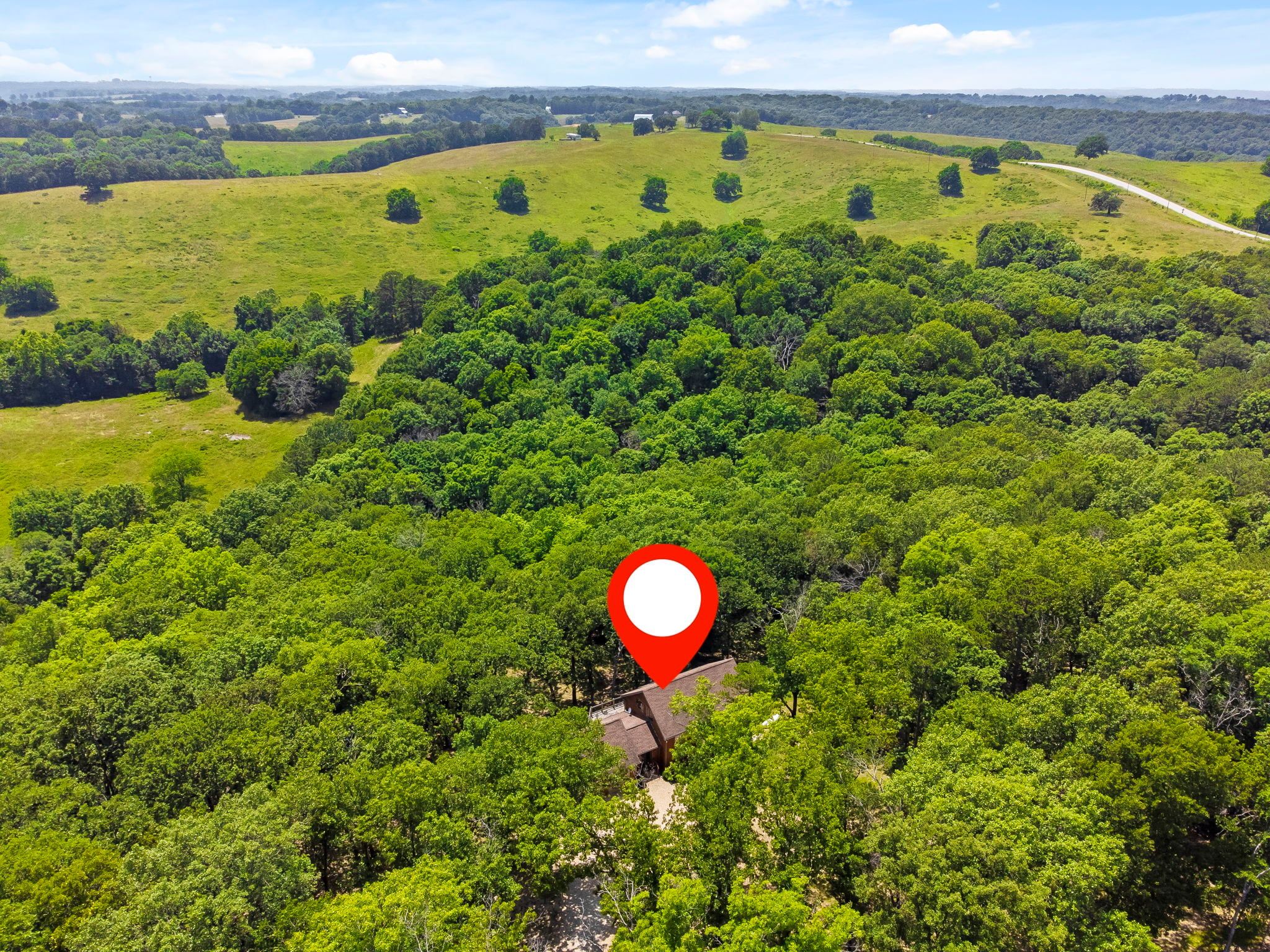 A rural landscape with a red location marker indicating a specific area.