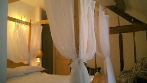 A bedroom with a four-poster bed, white bedding, and a wooden ceiling. - Group and Family Adventures in the Country Sleeps 19 (Machynlleth)