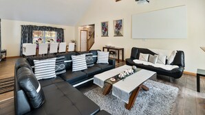 A spacious living room with a black leather sofa set, a coffee table, and a fireplace.