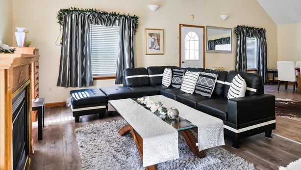 A modern living room with a sectional sofa, a fireplace, and a dining area.