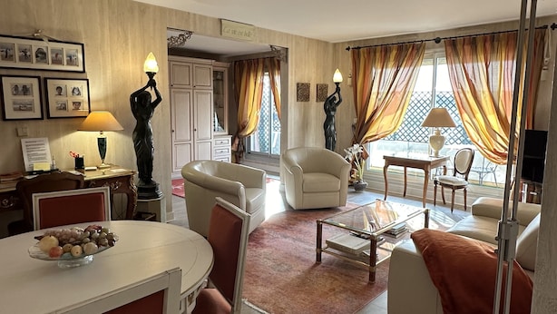 A living room with a dining area, featuring a white table, chairs, and a coffee table. There are two sofas and a TV in the background. - Luxury Apartment in Great Location. Come and be Parisian for a week! (Boulogne-Billancourt)