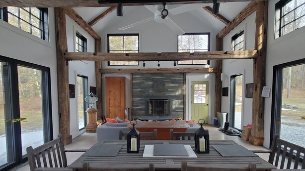 A spacious room with a large wooden dining table, multiple chairs, and a fireplace.