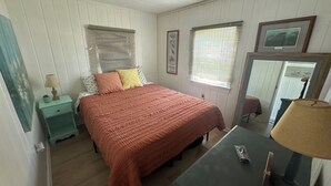 A bedroom with a bed, nightstands, a dresser, and a mirror. - Port Bay Waterfront Cottage — Your Private Lakeside Escape (Wolcott)