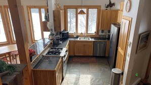 Una cocina moderna con armarios de madera, una estufa a gas y un lavavajillas de acero inoxidable.