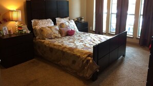 A bedroom with a bed, nightstands, a lamp, a picture frame, and a window with curtains. - Joe Pool Lake Resort Style-Upscale Gorgeous Home!!! (Grand Prairie)