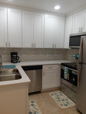 Kitchen features a stainless steel sink, dishwasher, microwave, coffee maker, and toaster.