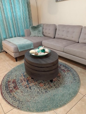 Relax in this inviting living room with a tufted sofa and patterned rug.