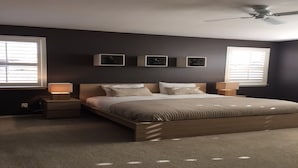 A bedroom with a large bed, two bedside tables, and a ceiling fan. - Goodyear Private Outdoor Pool Baseball Golf WIFI Parks Hike Nascar (Goodyear)