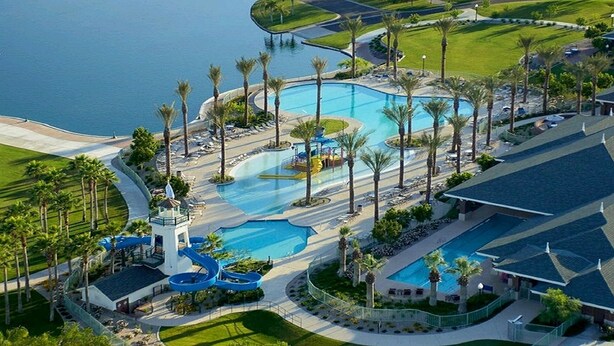 An aerial view of a resort with multiple swimming pools, palm trees, and a beach area. - Goodyear Private Outdoor Pool Baseball Golf WIFI Parks Hike Nascar (Goodyear)