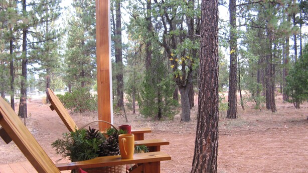 A wooden deck with a bench and a table, surrounded by trees. - Wonderful Winter Escape with Mountain views in Forest-like setting (Burney)