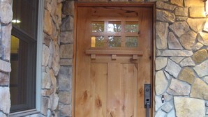 A wooden door with a stone wall, a window, and a welcome mat. - Wonderful Winter Escape with Mountain views in Forest-like setting (Burney)