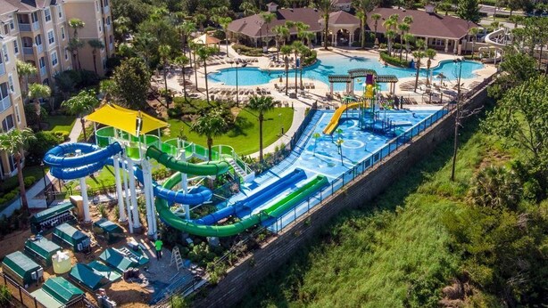 Un resort con varias piscinas, parque acuático y diversas zonas de estar al aire libre.