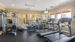 Un gimnasio con cintas de correr, máquinas de pesas y una máquina de remo.
