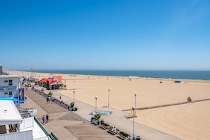 A beachside boardwalk with a sandy beach, a pier, and a few buildings including a diner.