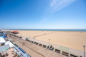 Eine Promenade mit Bänken und einem Strand im Hintergrund.