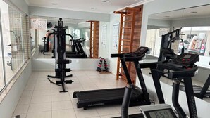 Ein Fitnessstudio mit Laufbändern, einem Ergometer und Krafttrainingsgeräten.