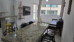 Eine moderne Küche mit Granit-Arbeitsplatte, einem Essbereich mit großem Tisch und einer kleinen Sitzecke.