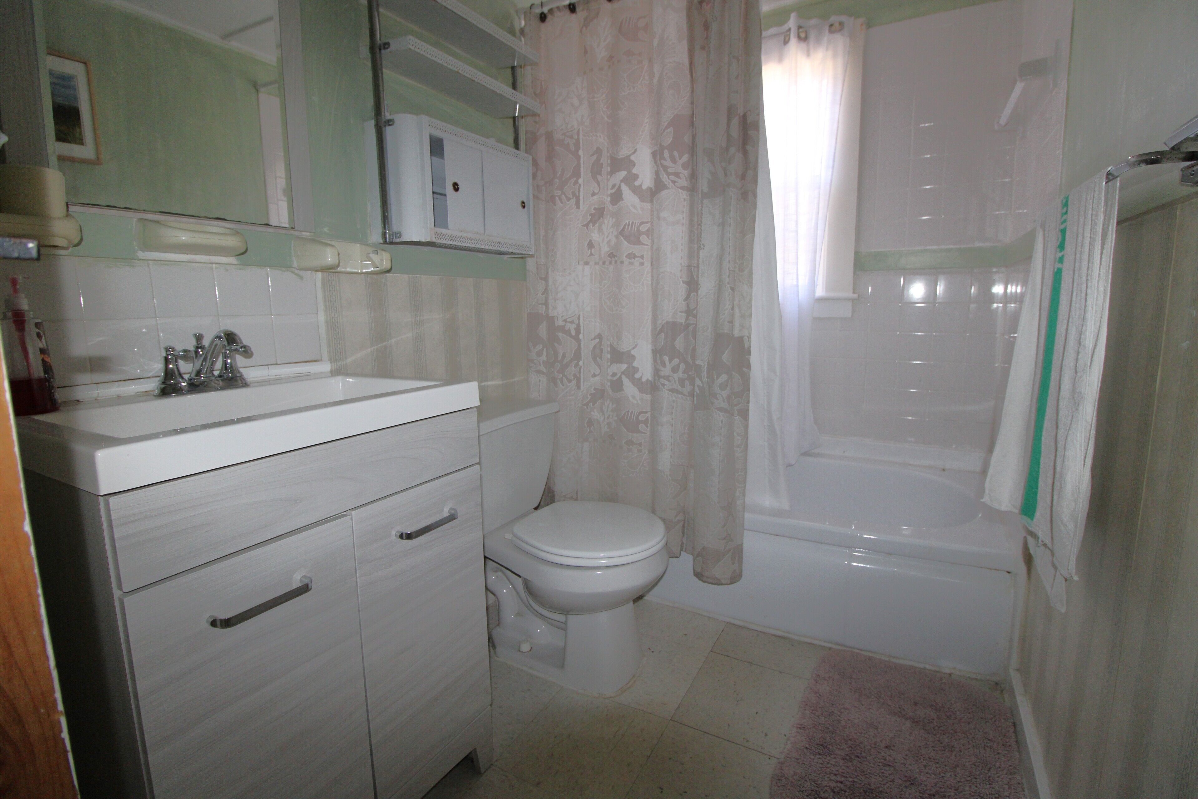 Une salle de bain avec des toilettes, un lavabo et une baignoire.