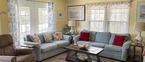 A cozy living room with a sectional sofa, a brown armchair, and a coffee table.