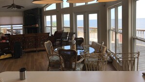 A spacious living area with a large window overlooking the sea, furnished with wicker chairs and a round table. - Gulf Front House, BoatDock/Spectacular View, Central A/C (Horseshoe Beach)