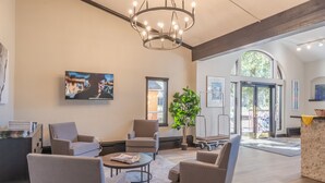 Una hall spaziosa con arredi moderni, un lampadario importante e opere d'arte alle pareti.