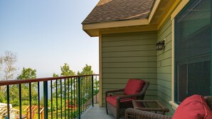 A balcony with wicker furniture and a view of the outdoors.