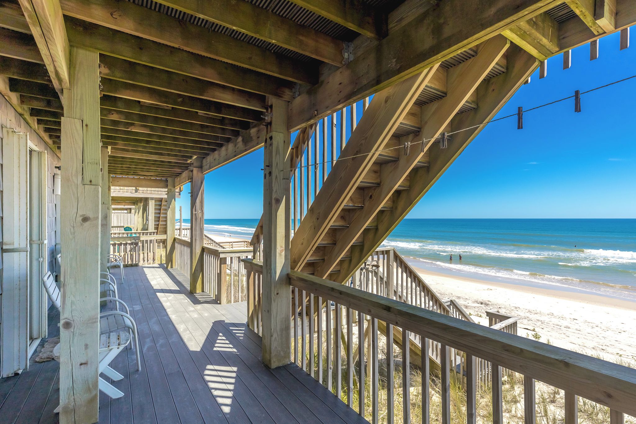 Una terraza de madera con vista a la playa.