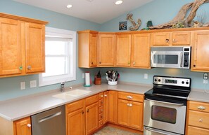 A kitchen with wooden cabinets, a stainless steel dishwasher, a microwave, and an oven.