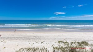 A beach with clear skies, a sandy shore, and sparse vegetation. - C' Turtle - 5 BR Oceanfront Home - Elevator, Spectacular Views from Decks (Surf City)