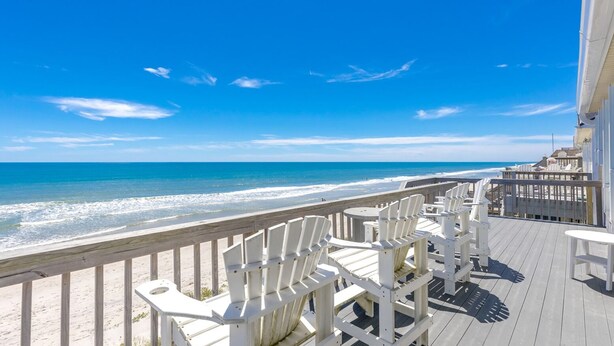 A beachside deck with white Adirondack chairs and a wooden railing overlooking the ocean. - C' Turtle - 5 BR Oceanfront Home - Elevator, Spectacular Views from Decks (Surf City)